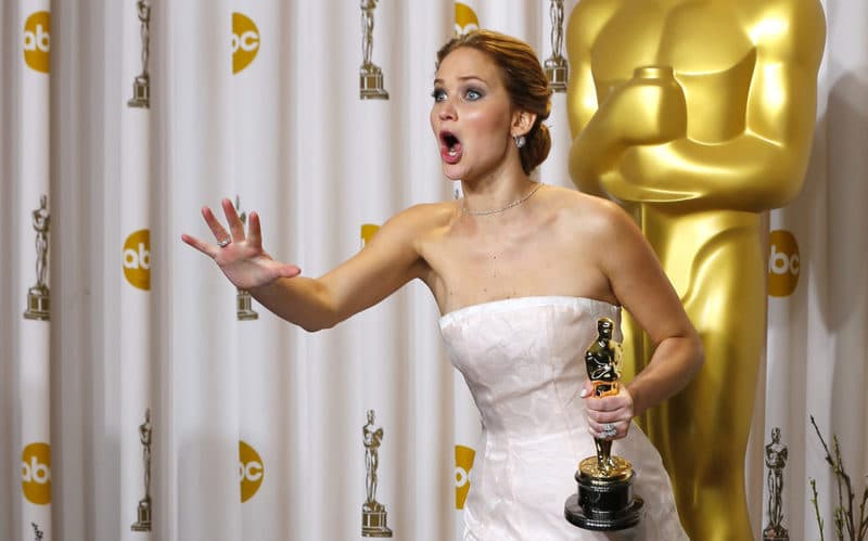 Jennifer Lawrence, best actress winner for her role in "Silver Linings Playbook," reacts after photographers made a picture of her making an obscene gesture as she took the stage in the photo room with her Oscar at the 85th Academy Awards in Hollywood, California February 24, 2013 REUTERS/Mike Blake (UNITED STATES - Tags: ENTERTAINMENT) (OSCARS-BACKSTAGE) - RTR3E9DL