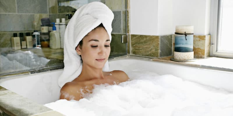 Mixed race woman having bubble bath