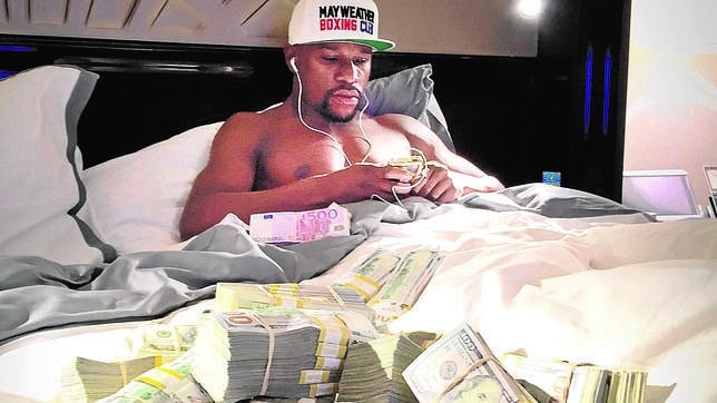 El boxeador Floyd Mayweather, en la cama rodeado de fajos de billetes