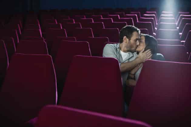 Couple kissing in an empty movie theatre