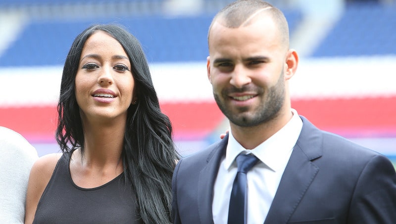 Spanish soccer player Jese Rodrigez, holds his new Paris Saint Germain jersey as he poses with his companion Aurah Ruiz, right, at Parc des Princes stadium in Paris, Monday, Aug. 8, 2016.