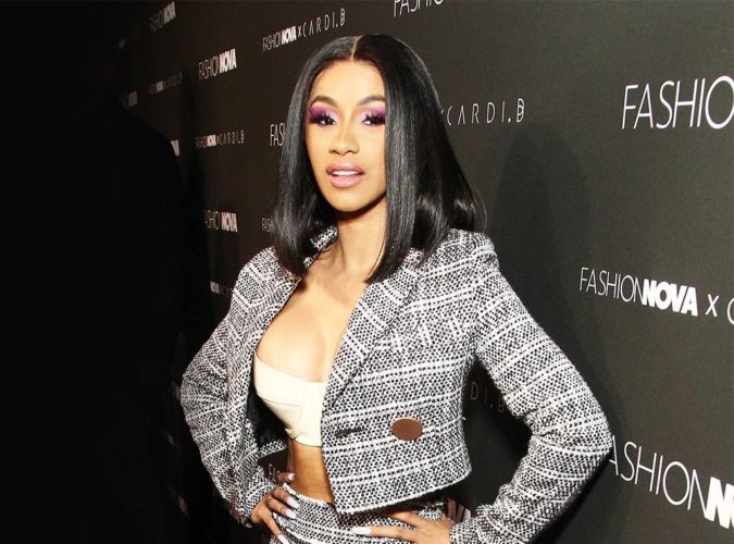 Cardi B posa con un traje gris en cámara