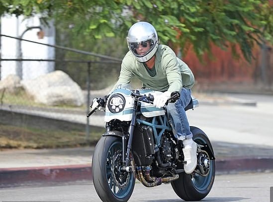 El actor Brad Pitt manejando su motocicleta.