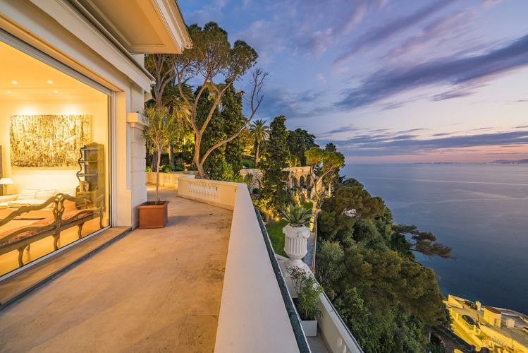 Detalles de la mansión que fue propiedad de Sean Connery, ubicada en la Riviera Francesa, rodeada de árboles con vista al mar.