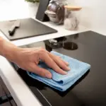 Persona limpiando vitroceramica.